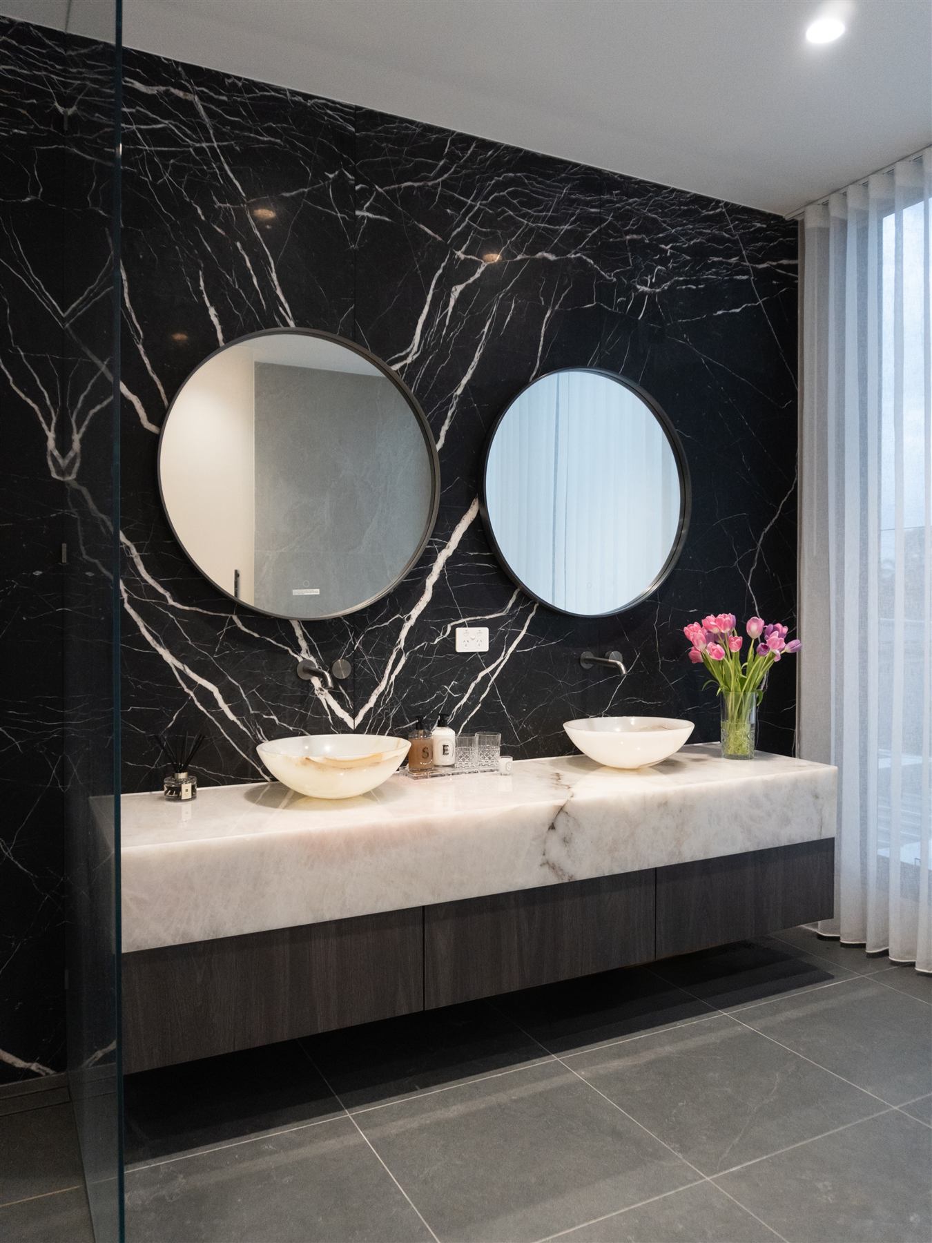 Master ensuite with Nero Marquina natural stone feature wall and Cristallo Pink Quartzite vanity